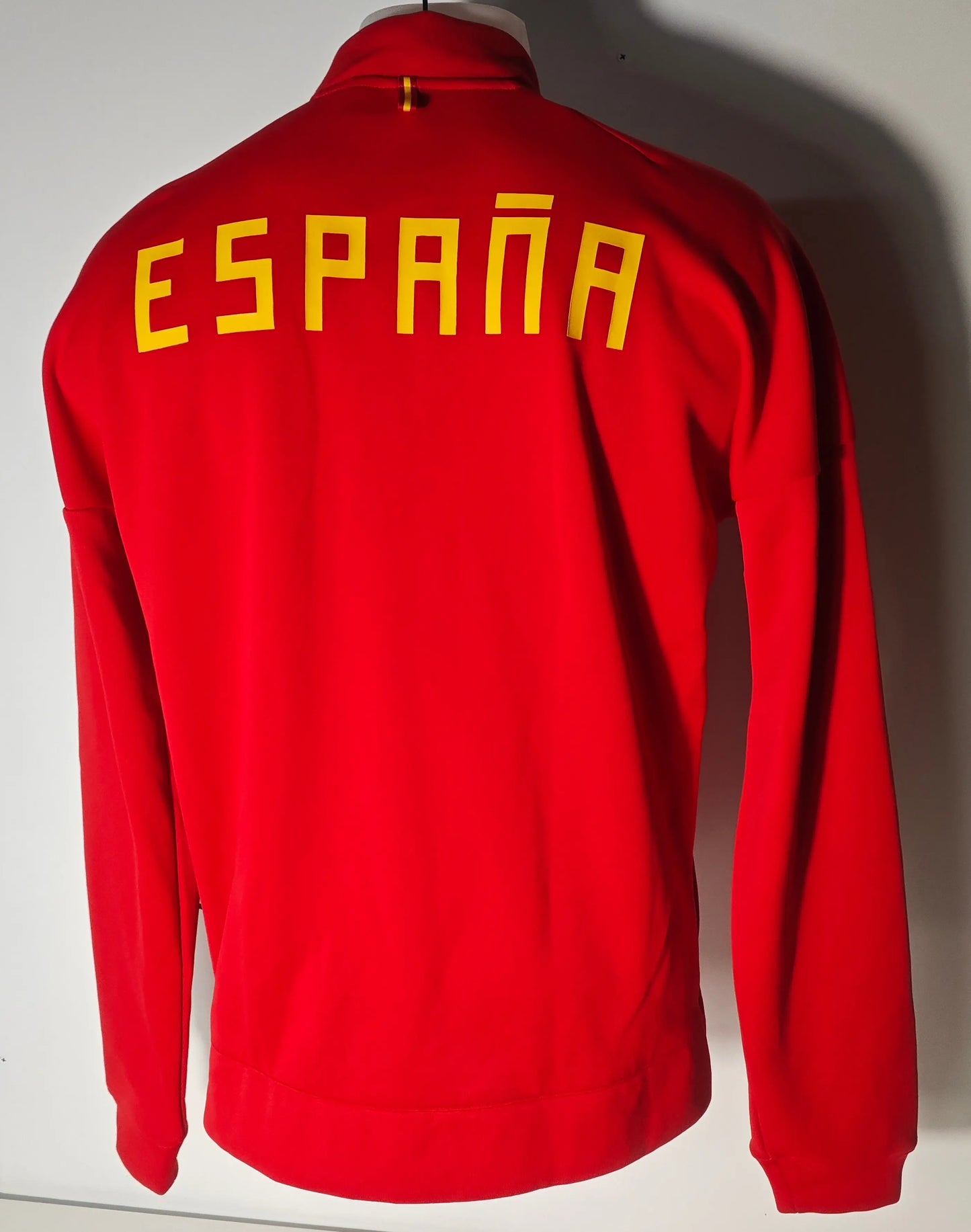 Veste de survêtement rouge et jaune officielle d'Adidas Espagne, avec l'inscription ESPAÑA dans le dos.