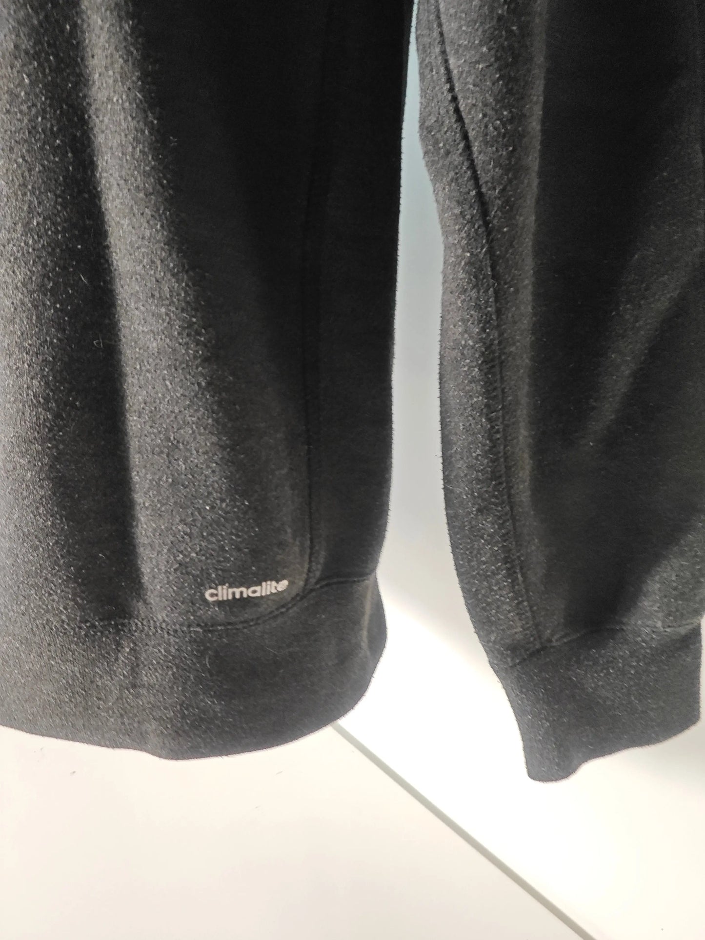 Sweat-shirt noir de sport Essentials Adidas avec le logo "Climalite" sur le devant.
