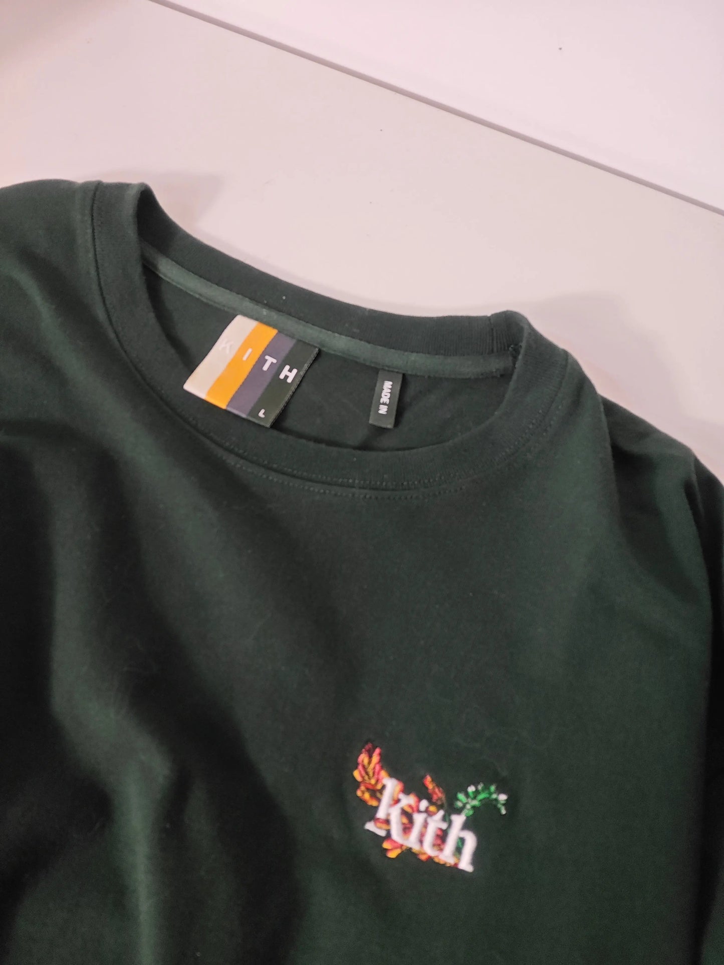 T-shirt vert foncé Kith avec logo floral brodé et détails de taille L.