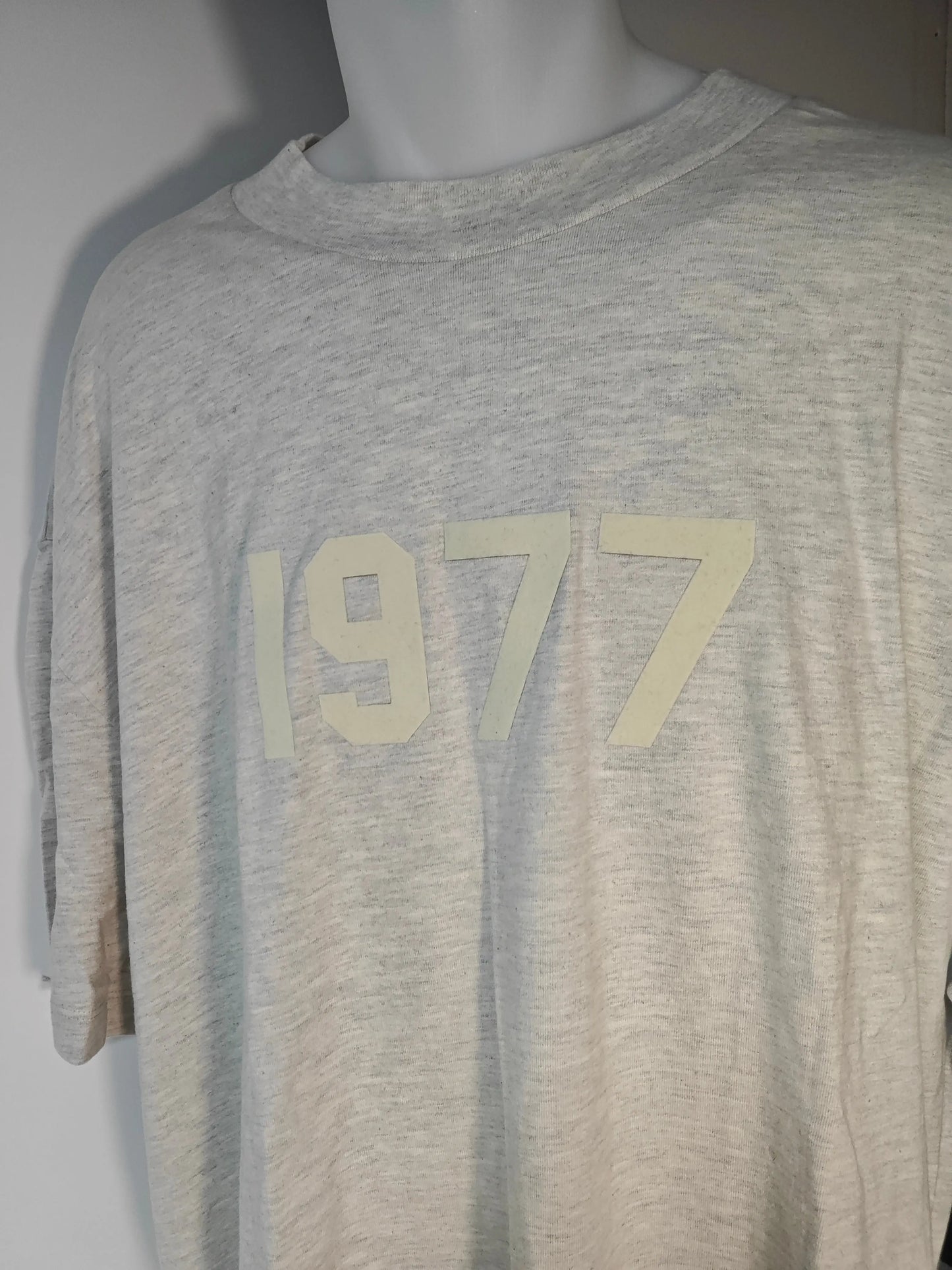 T-shirt beige chiné de Essentials Fear of God, avec l'inscription "1977" ton sur ton sur le devant.