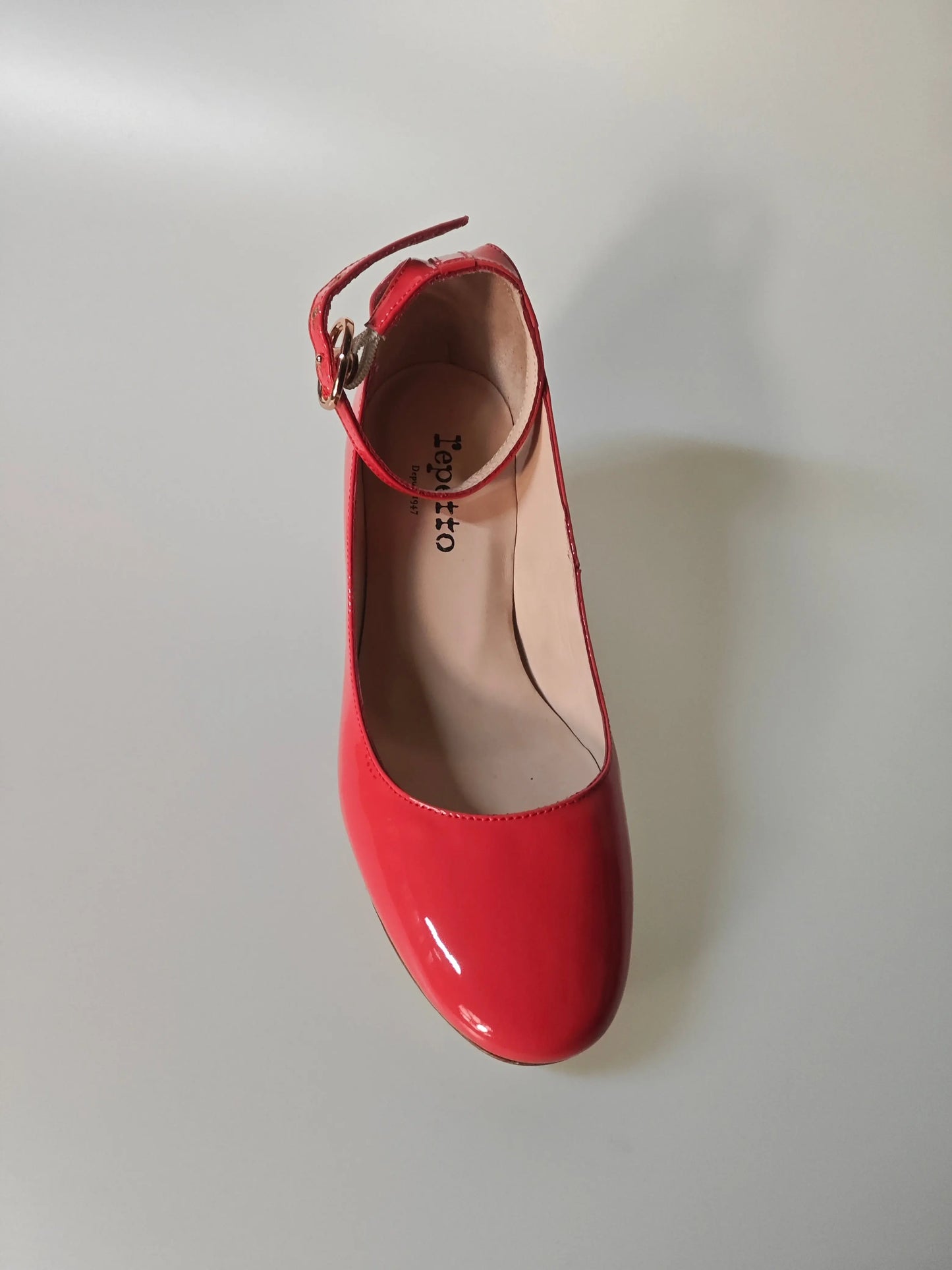 Escarpin rouge verni à bride, de Repetto, avec boucle dorée et intérieur en cuir clair.