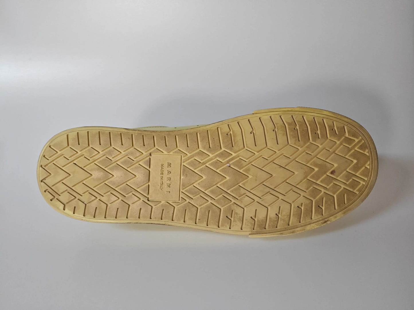 Semelle de chaussure jaune de Marni, motif géométrique à chevrons, inscription « Made in Italy » au centre.
