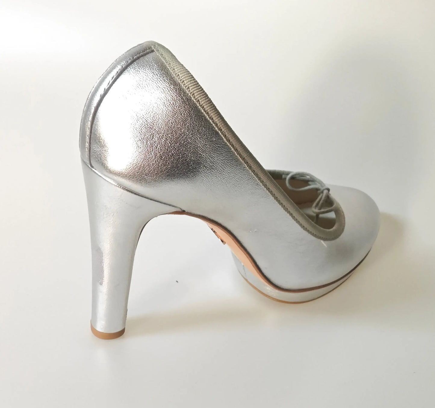 Escarpin argenté à talon avec bride, par Repetto, sur un fond blanc uni.