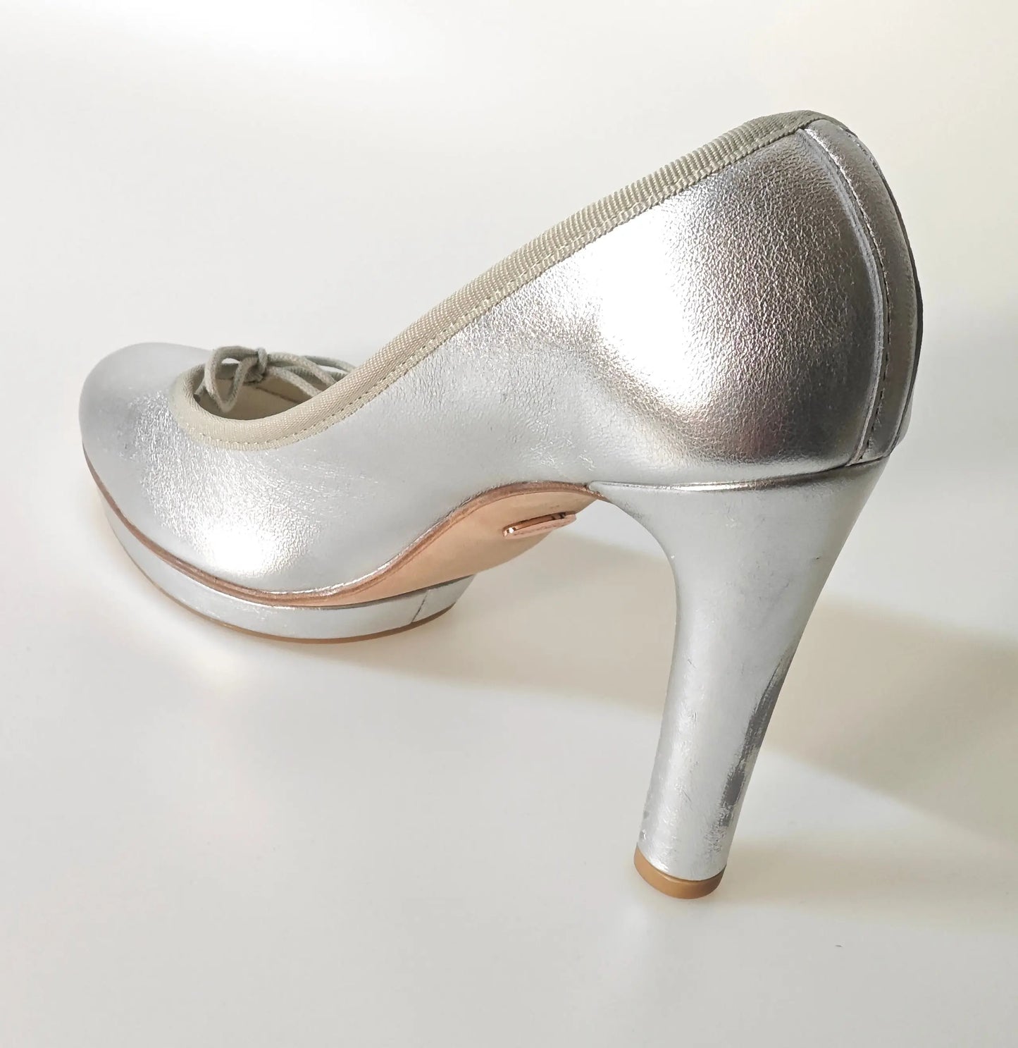 Escarpin argenté Repetto avec talon aiguille, vu de côté sur fond blanc.