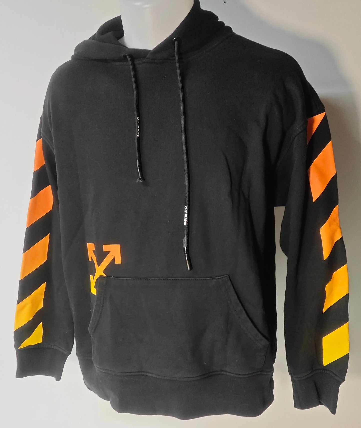Sweat à capuche noir par Off-White, avec motif flèche orange et rayures sur les manches.