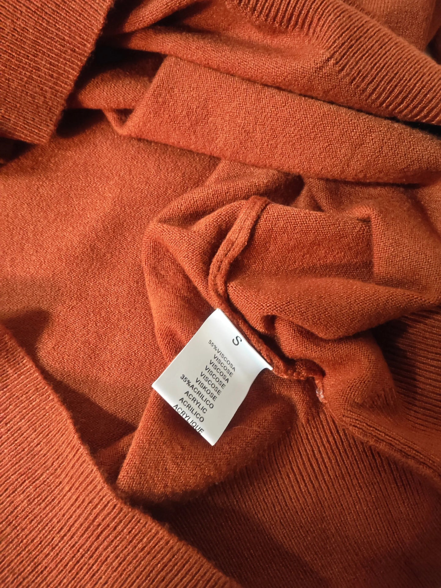 Pull à col en V doux en viscose d'Upstyle Destock, de couleur rouille avec une étiquette de composition.