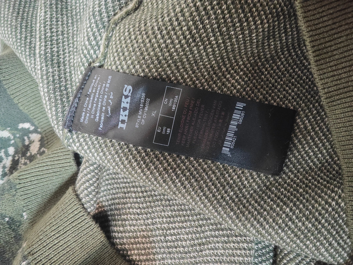 Pull IKKS camouflage à motif chiné, détail de l'étiquette de composition.