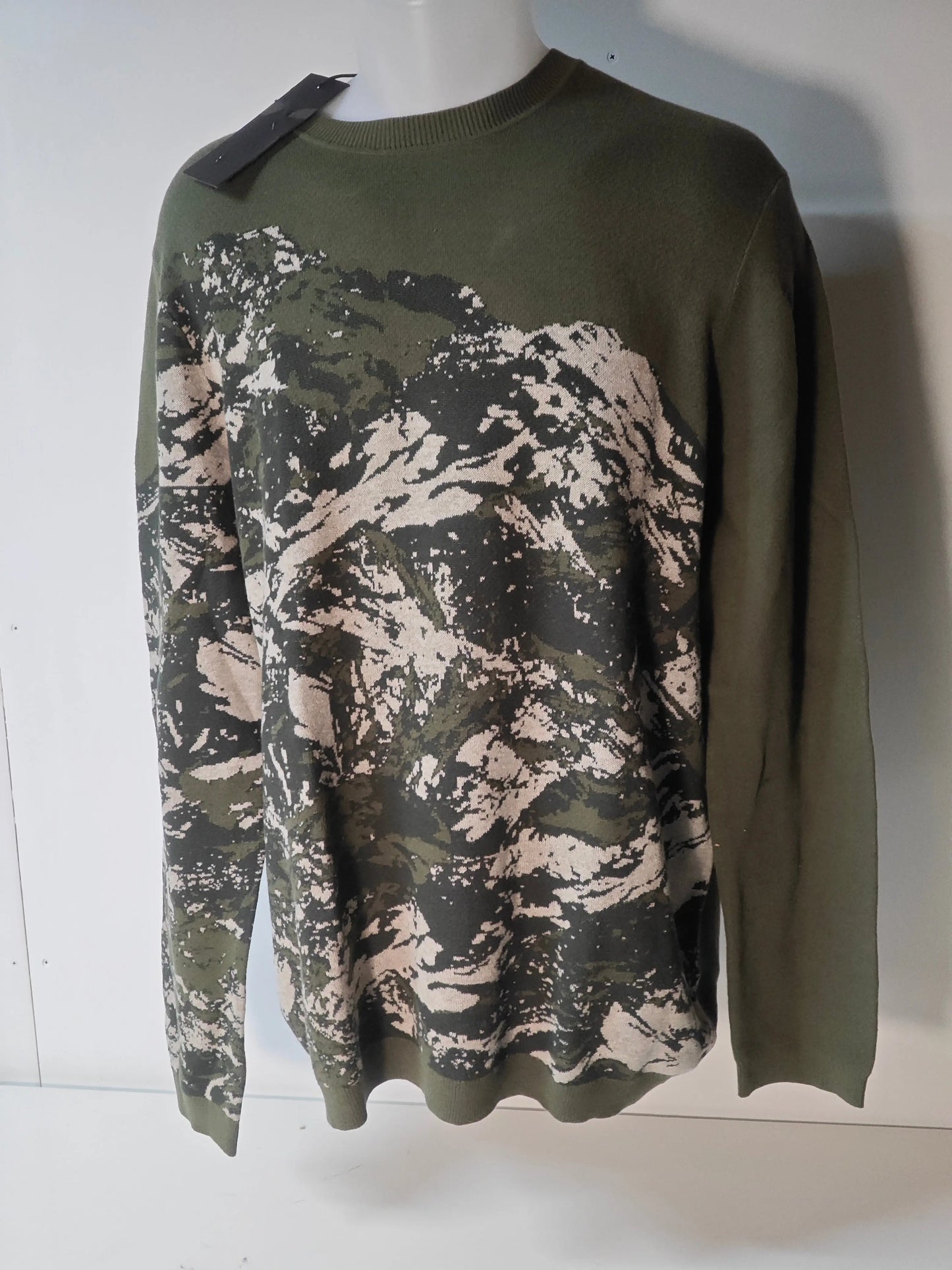 Pull IKKS camouflage en maille, par ikks, avec un motif abstrait sur le devant et une étiquette noire.