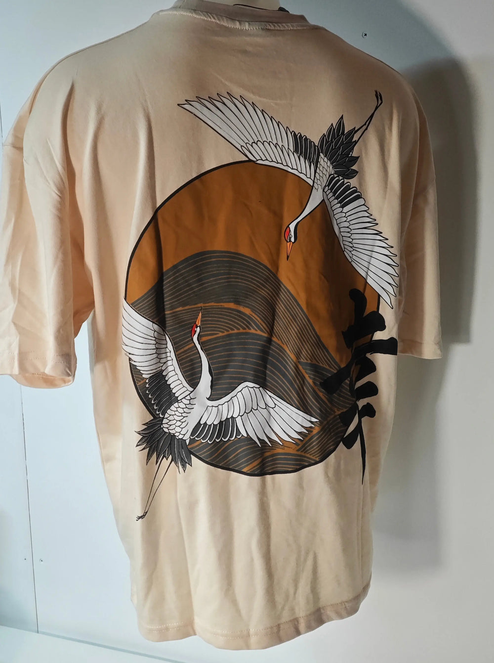 T-shirt beige AOTS Art Of The Streets avec motif de deux grues japonaises dans un cercle brun.