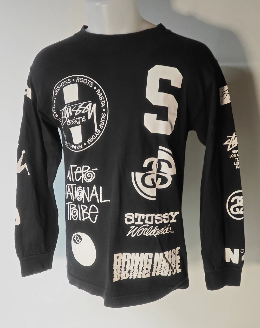 T-shirt noir à manches longues de Stüssy, orné de logos blancs variés et modernes.