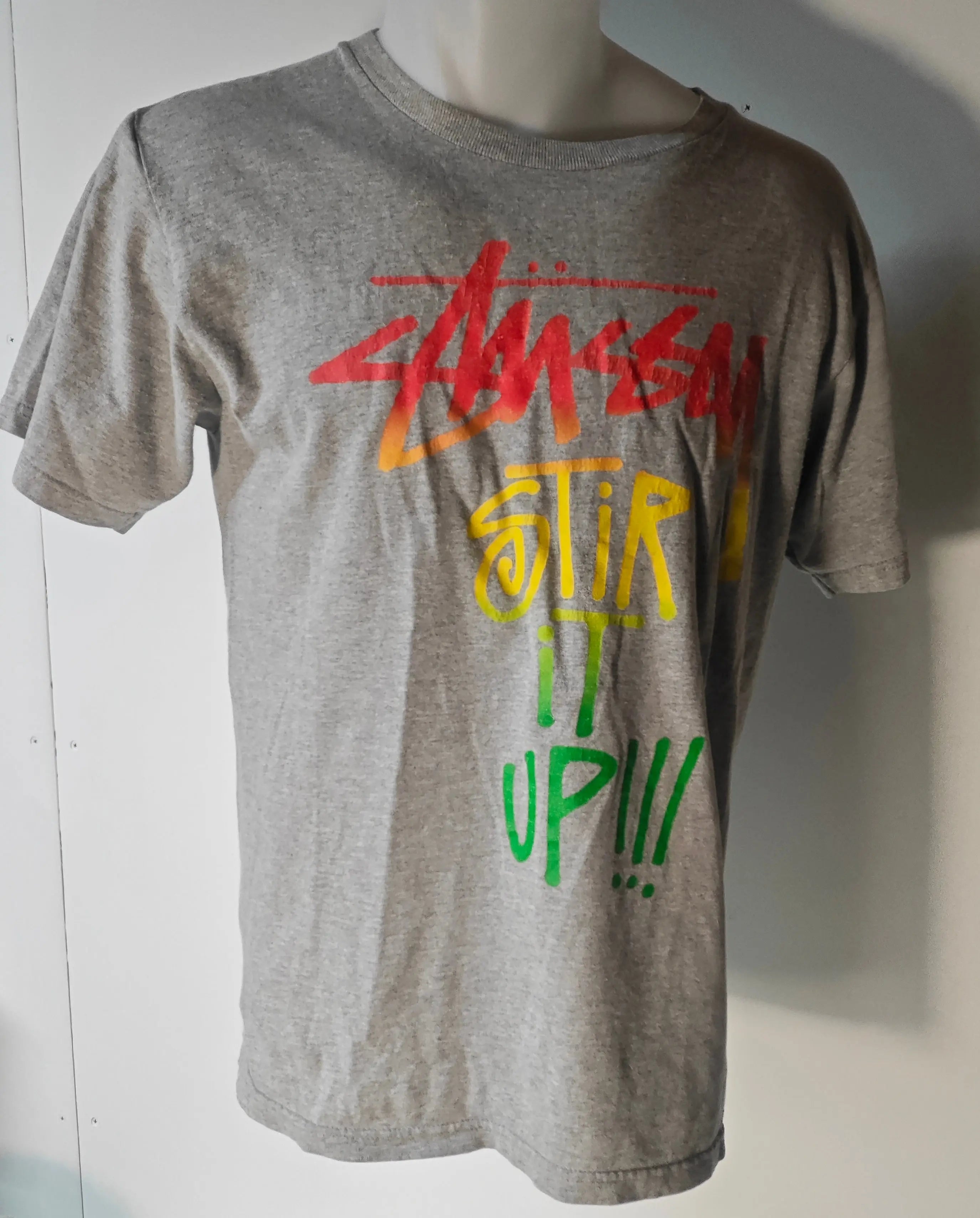 T-shirt gris taille S de Stüssy, avec inscription multicolore et manches courtes.