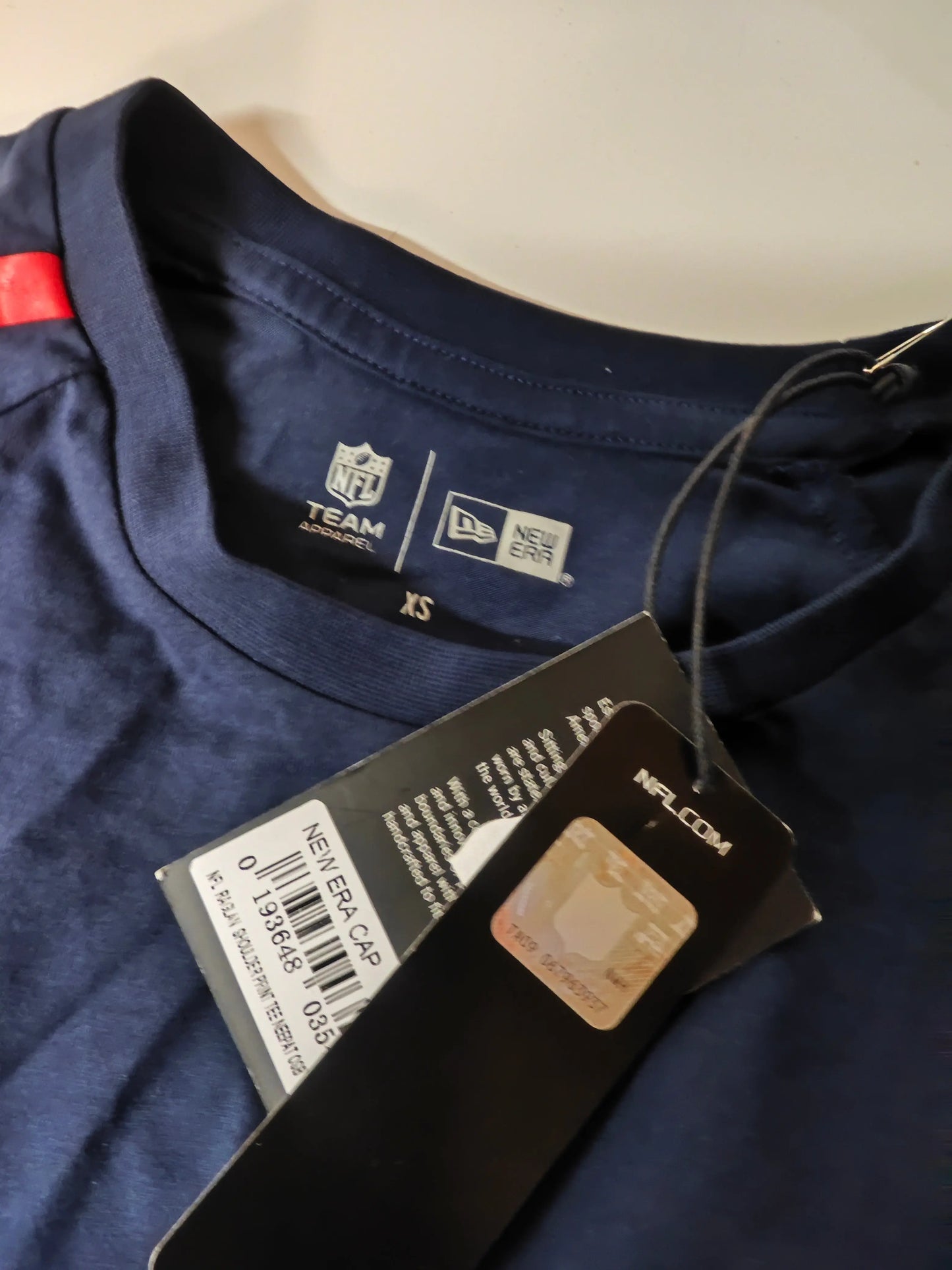 T-shirt NFL bleu marine à manches raglan, par New Era, avec logo d'équipe et étiquette.