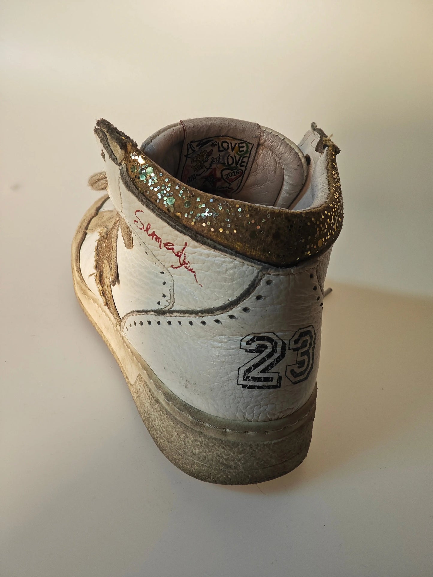 Baskets montantes en cuir blanc et daim, de SMR 23, avec inscription rouge et talon pailleté.