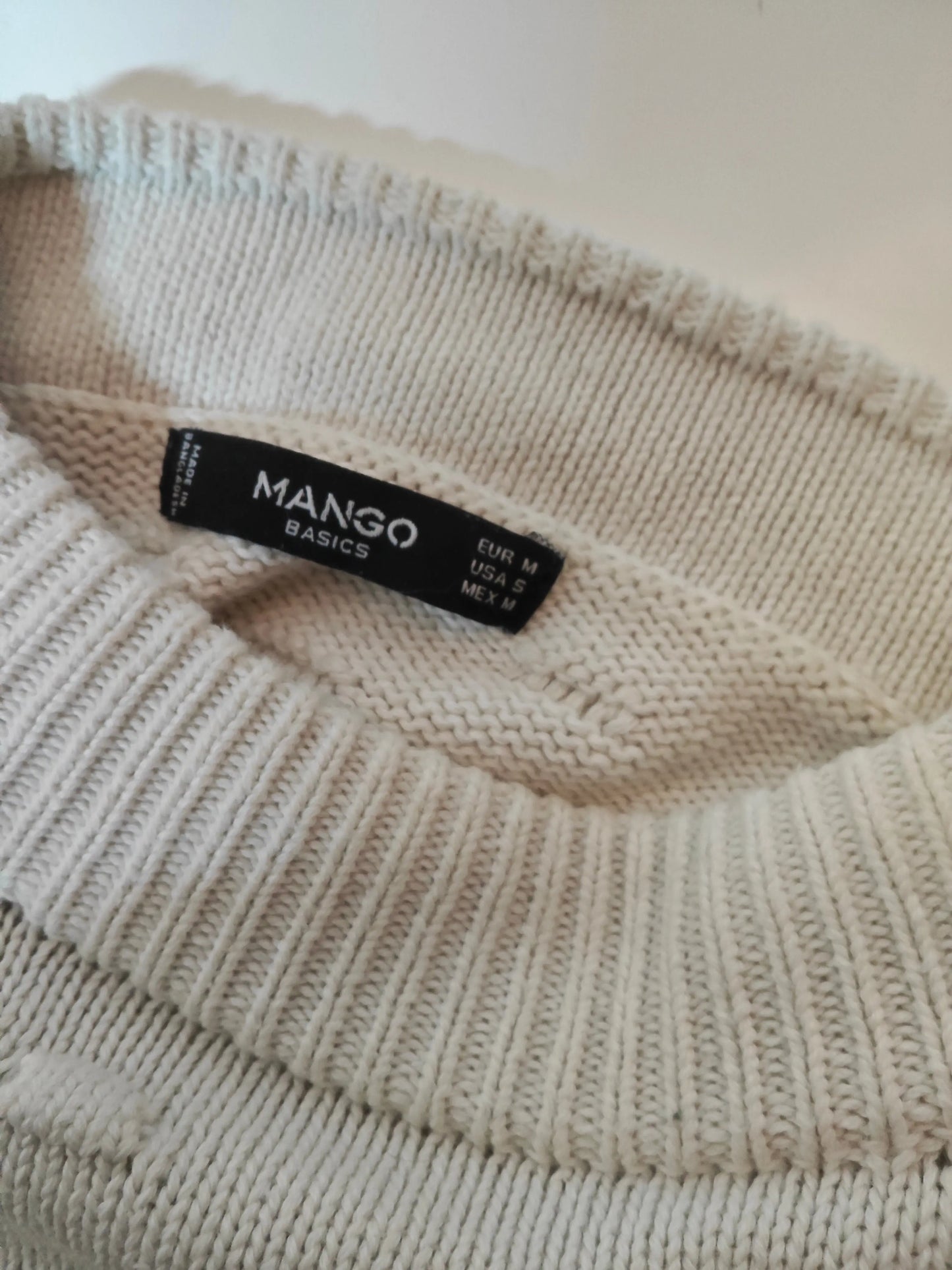 Pull rayé blanc et marine de Mango, en maille texturée, avec une étiquette de taille visible.