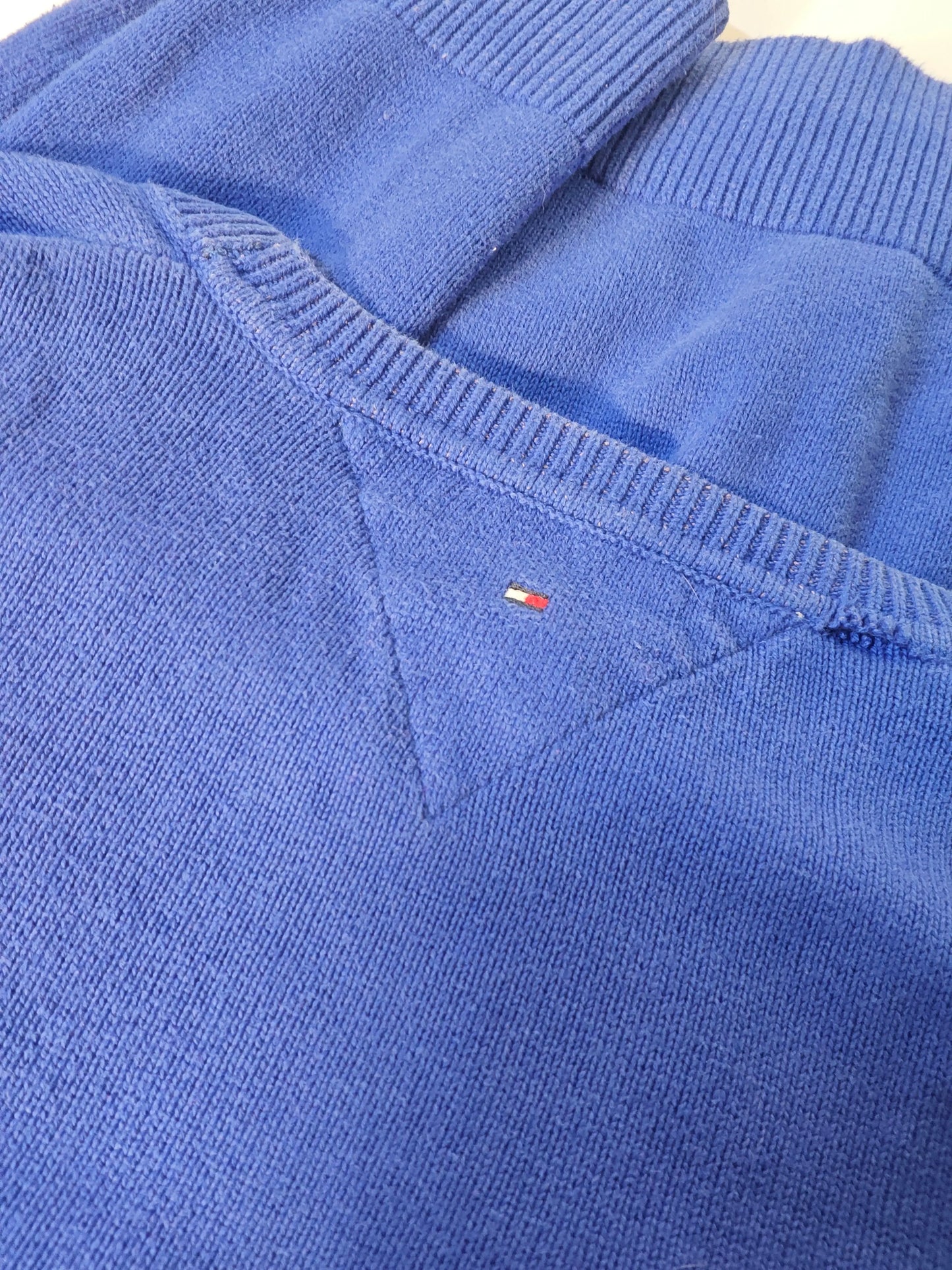 Pull bleu en tricot de Tommy Hilfiger, avec le logo emblématique sur la poitrine et le col côtelé.