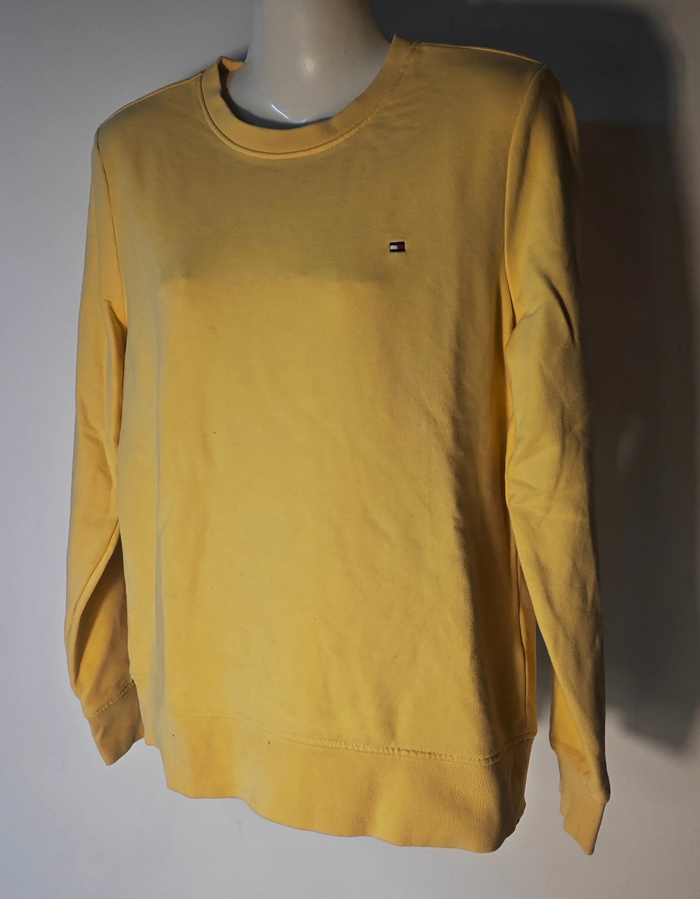 Sweat jaune de Tommy Hilfiger, uni avec logo sur la poitrine, présenté sur un mannequin.