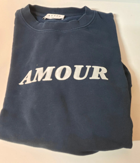 Sweat bleu marine avec inscription "AMOUR" en blanc de Sandro, plié.