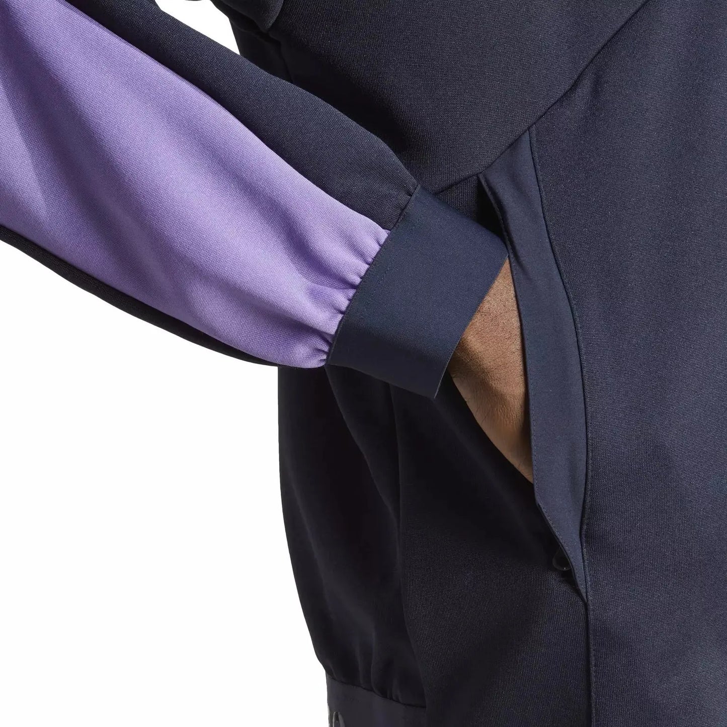 Veste de survêtement bleue et mauve Adidas avec une poche, portée par un modèle, vue de près.