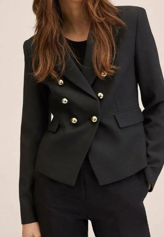 Blazer noir à double boutonnage de Mango, avec boutons dorés et coupe courte.