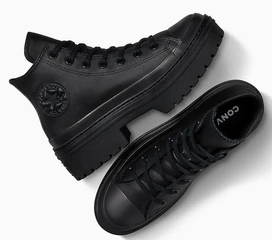 Baskets montantes noires à semelles épaisses de Converse, avec logo rond sur le côté.