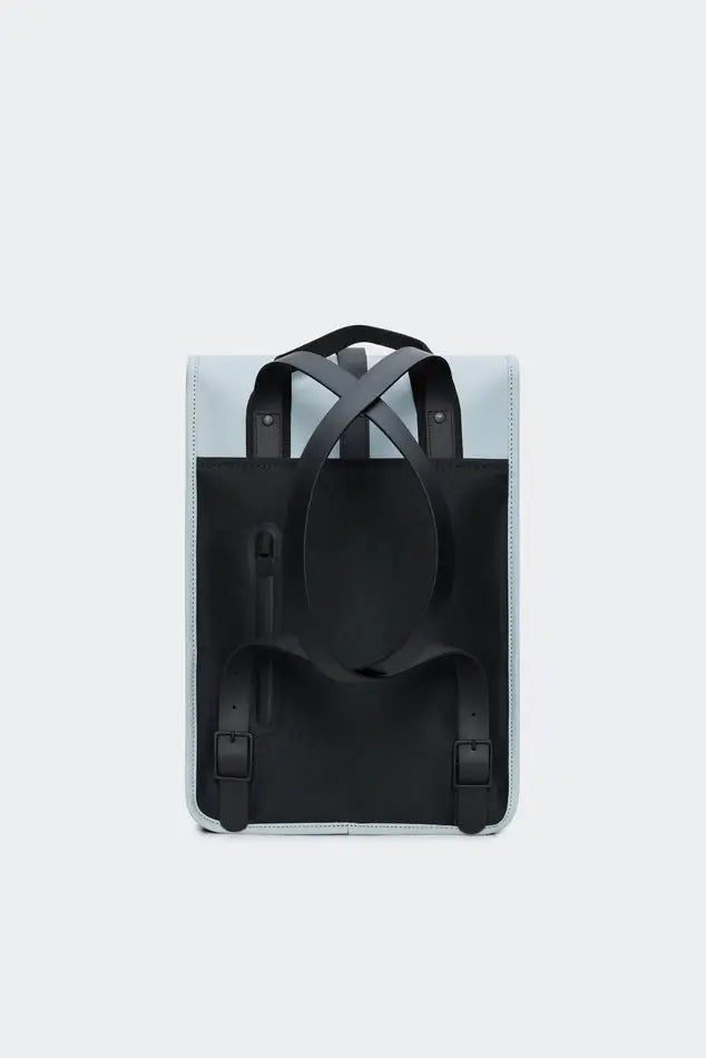 Sac à dos bleu clair/pastel de Rains, avec des bretelles noires croisées et un panneau arrière noir.