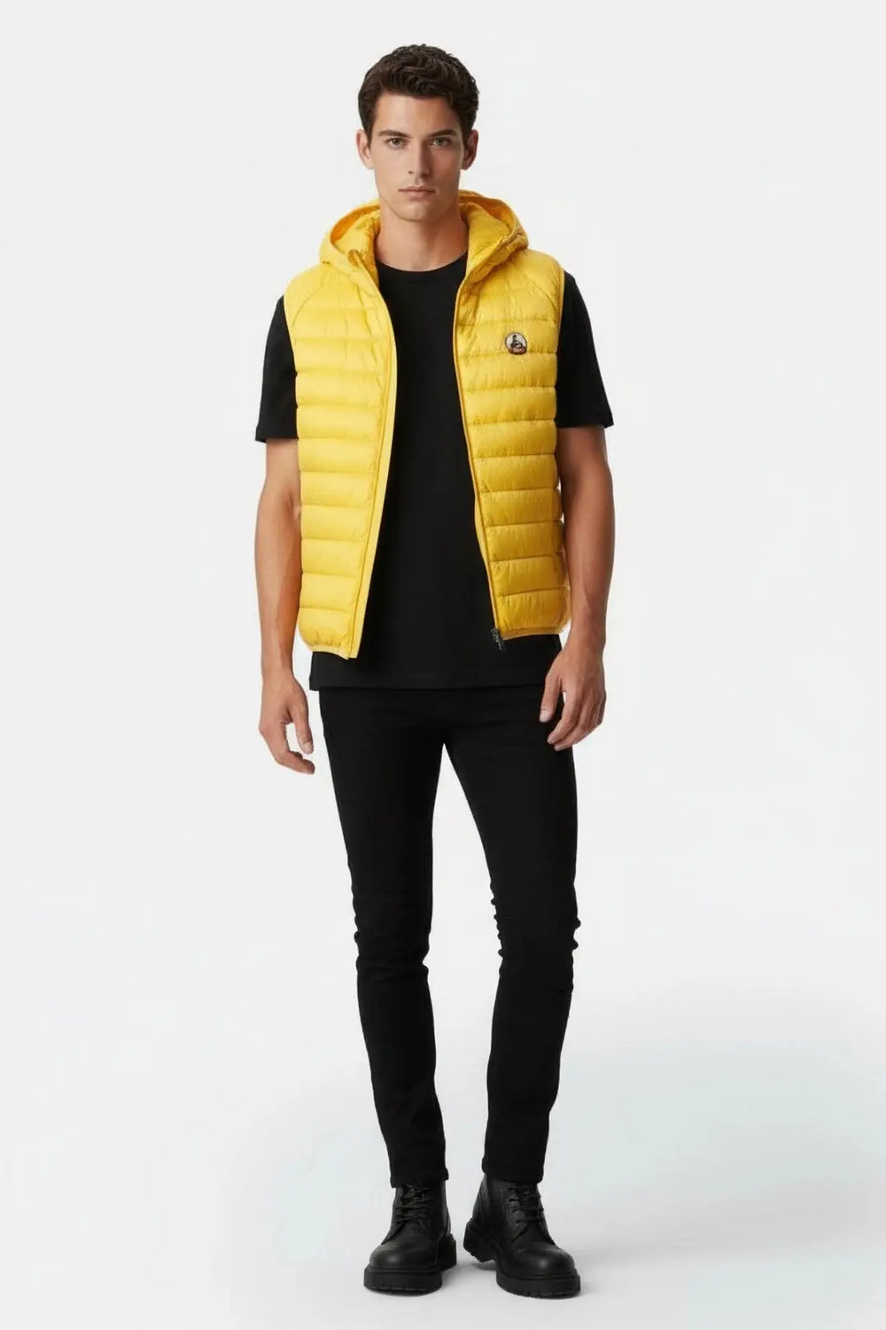 Doudoune sans manches jaune JOTT à capuche, portée sur un t-shirt et un jean noirs.
