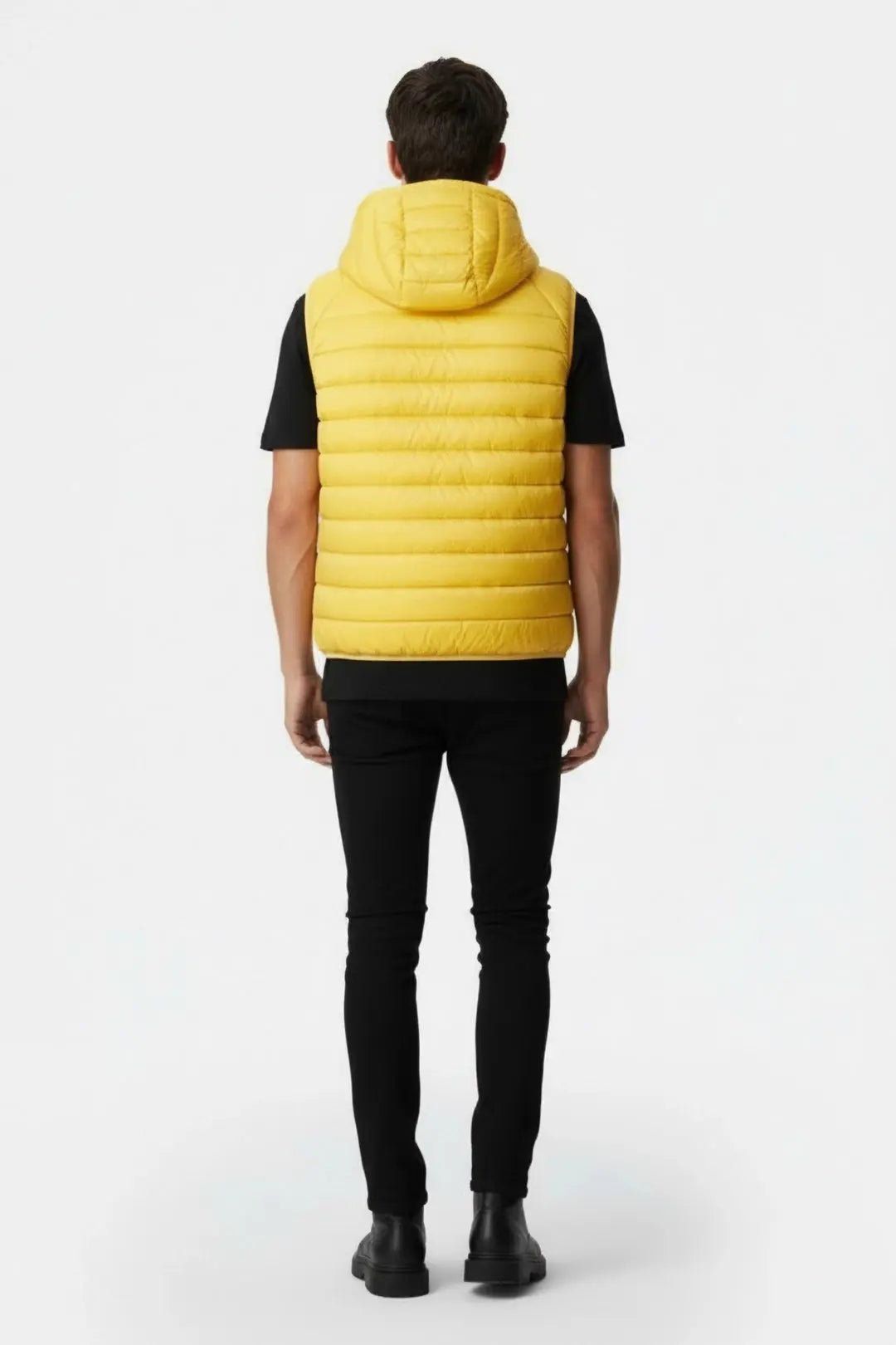 Doudoune sans manches jaune de JOTT, portée sur un t-shirt noir et un jean noir, vue de dos.