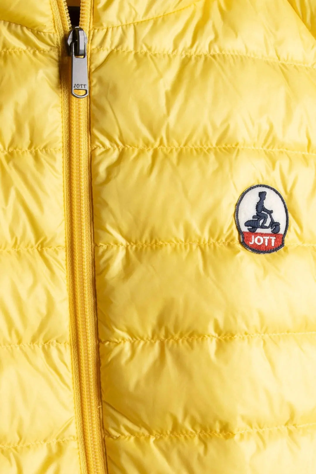 Doudoune jaune sans manches de Jott, avec fermeture éclair et logo de la marque.