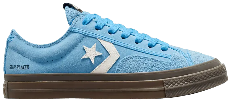 Baskets basses bleues en daim de Converse, avec logo étoile blanc sur le côté et semelle marron.