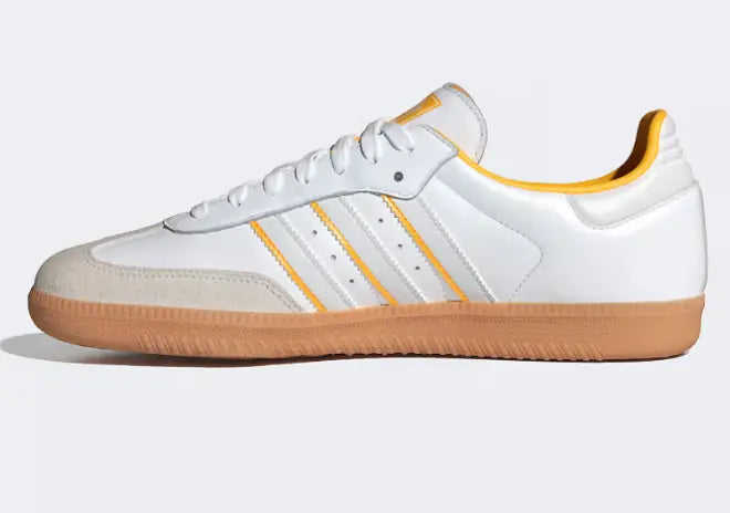 Chaussure de sport blanche et jaune par Adidas, avec semelle extérieure marron.