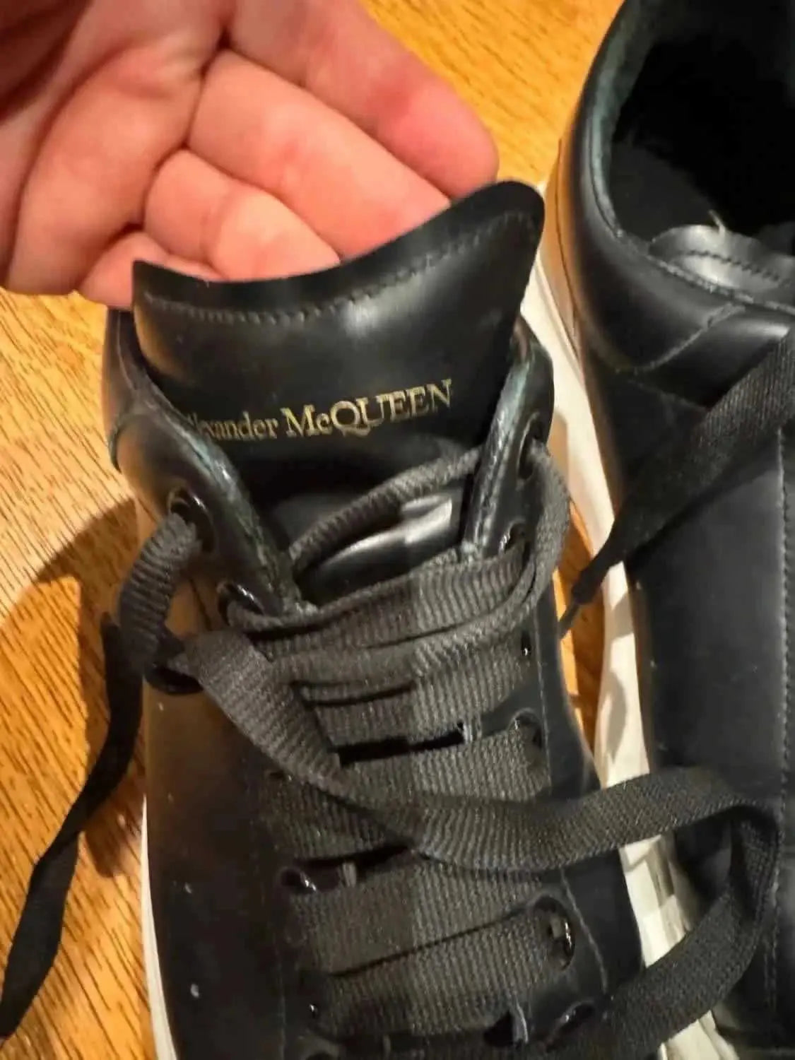 Baskets noires de seconde main d'Alexander McQueen, avec lacets et détails en cuir visibles.
