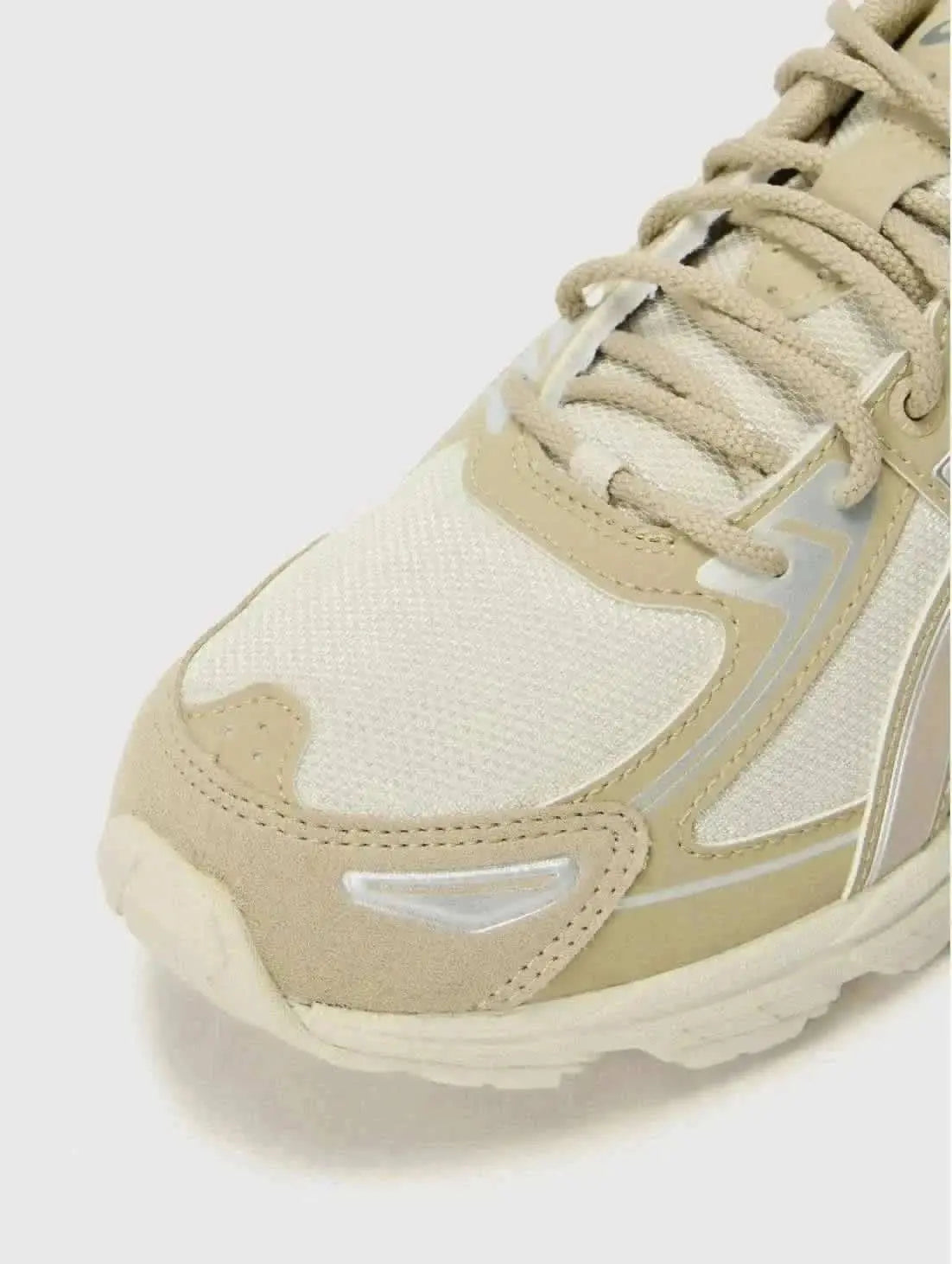 Sneaker beige Asics Gel-Venture 6, en gros plan avec des détails argentés et des lacets assortis.