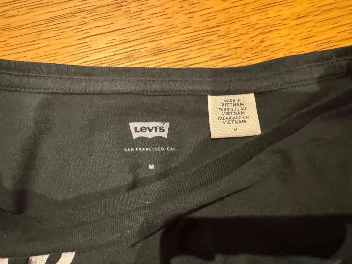 T-shirt noir à logo vintage de Levi’s, avec étiquette de fabrication et indication de la taille.