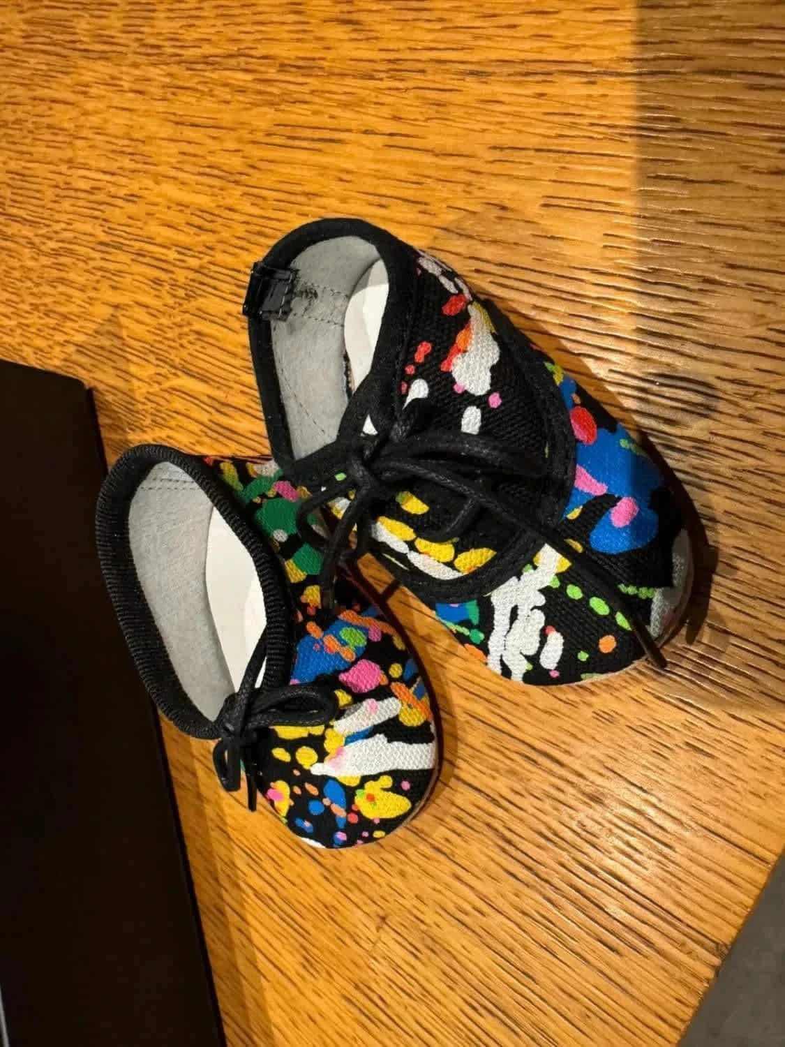 Chaussons Repetto bébé noir multico par Repetto, taille 16/17, avec motif éclaboussures de peinture colorées.