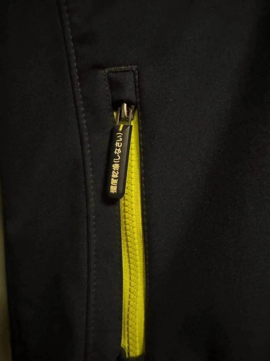 Veste noire de sport par Superdry avec fermeture éclair jaune vif.