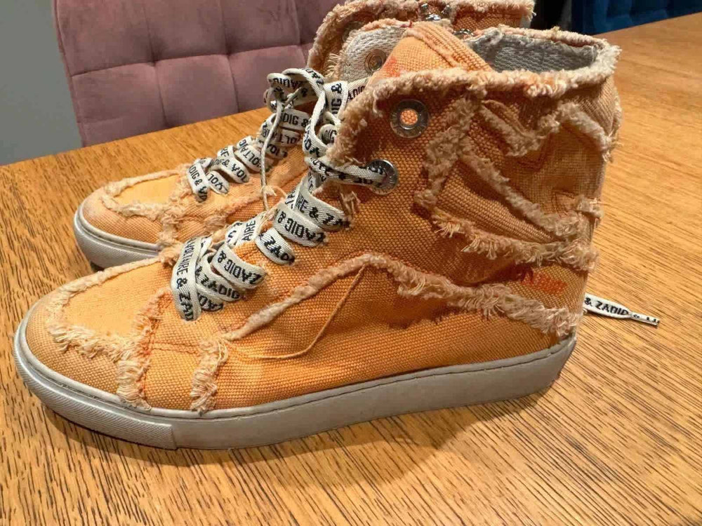 Baskets montantes orange effilochées de Zadig & Voltaire, avec lacets à motifs et détails usés.