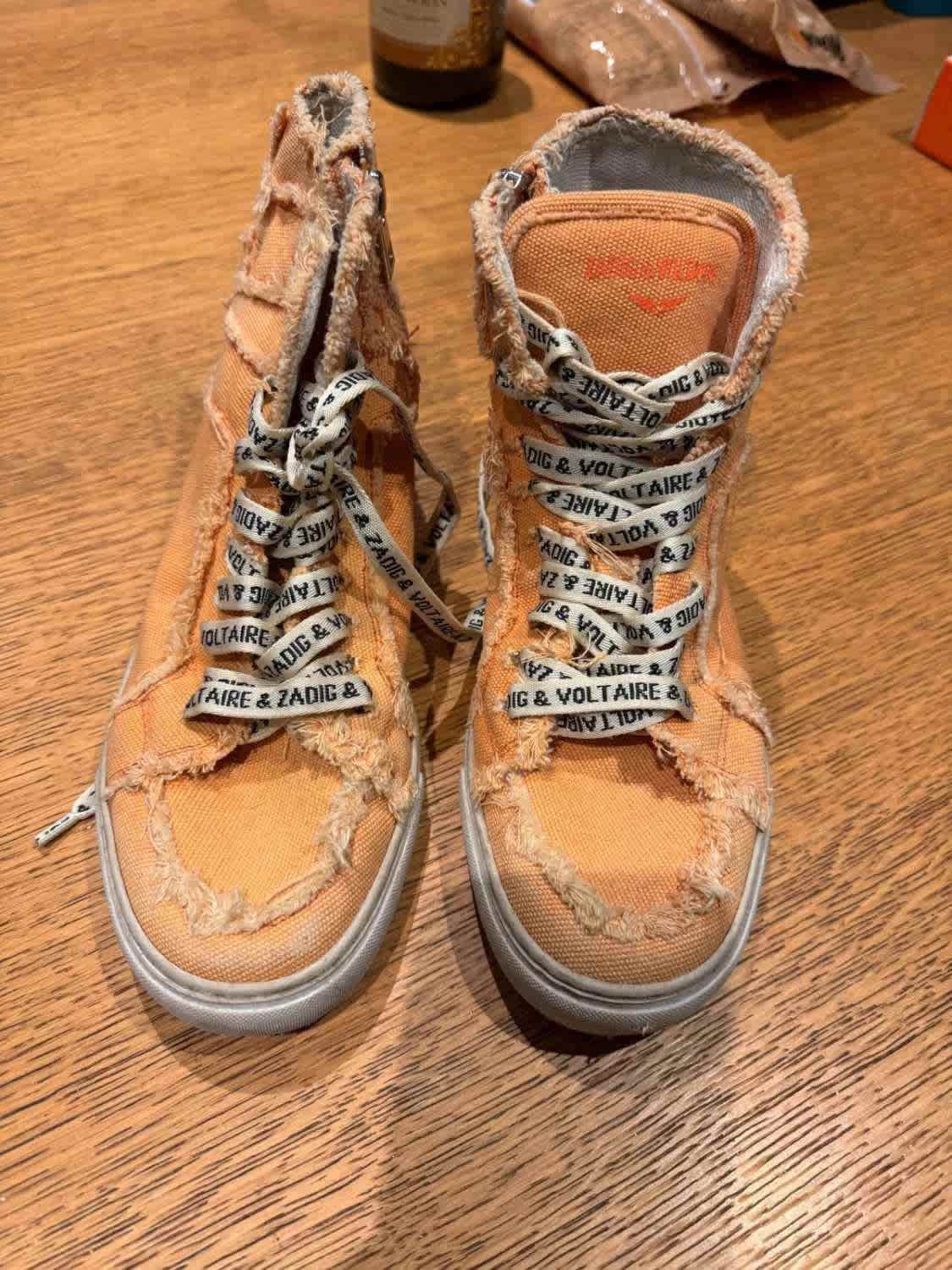 Baskets montantes orange de Zadig & Voltaire, avec lacets à motifs griffés et détails usés.