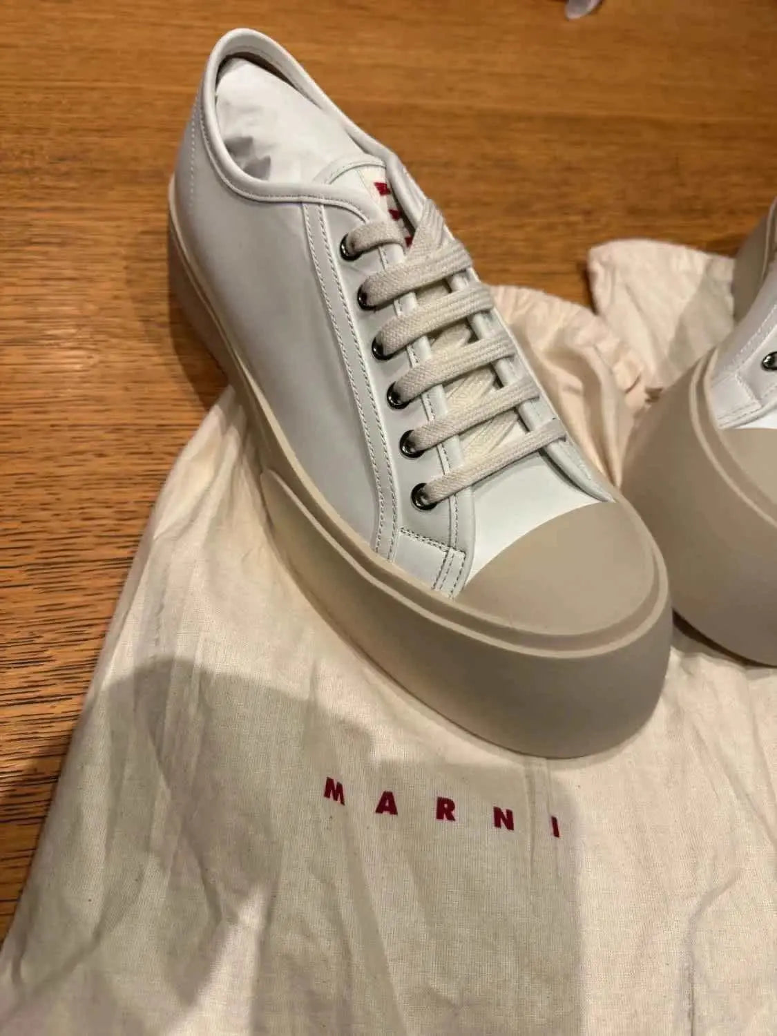 Baskets Marni Pablo en cuir nappa blanc de Marni, posées sur une housse de protection en toile.