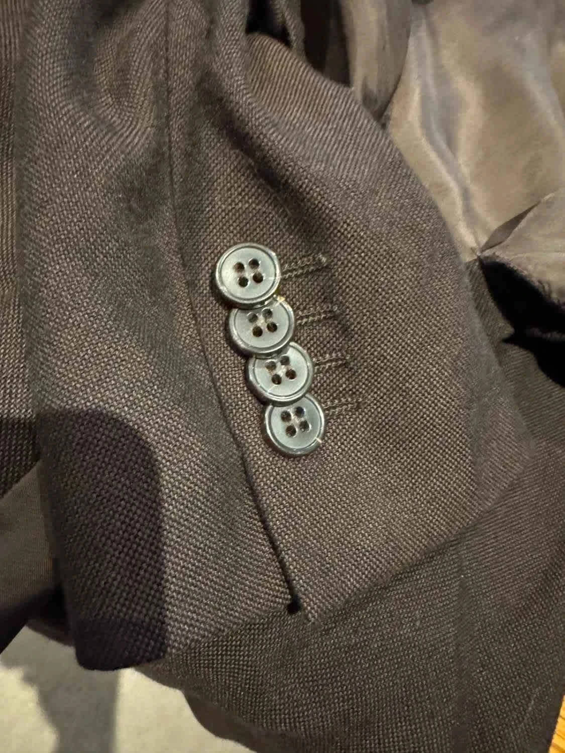 Blazer marron foncé taille XL de Zegna, avec quatre boutons gris sur la manche.