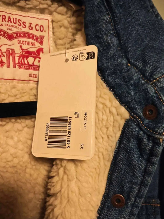 Veste en denim sherpa neuve de Levi's avec une étiquette beige indiquant la taille XS.