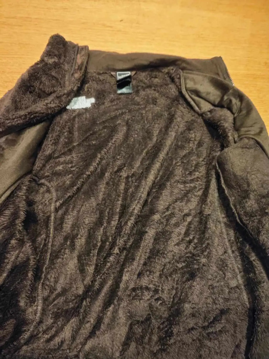 Veste polaire marron du The North Face avec une doublure en peluche visible.