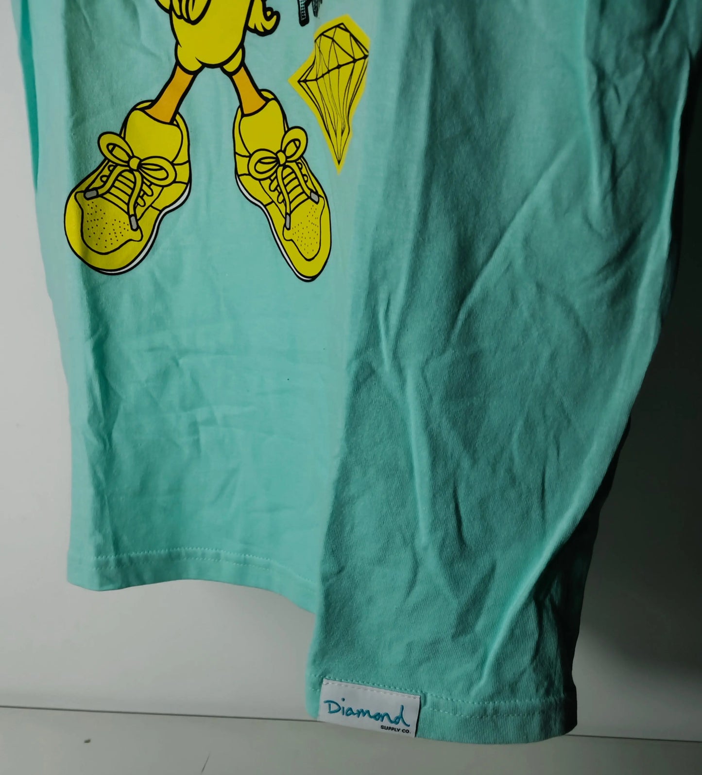 T-shirt bleu à motif imprimé, de Diamond Supply Co., avec personnage Looney Tunes et logo de marque.
