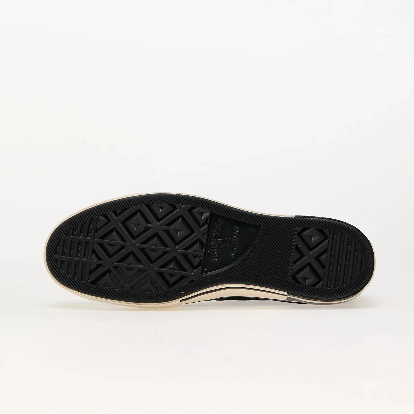 Semelle de chaussure noire et blanche de Converse, avec motif à losanges et logo en relief.
