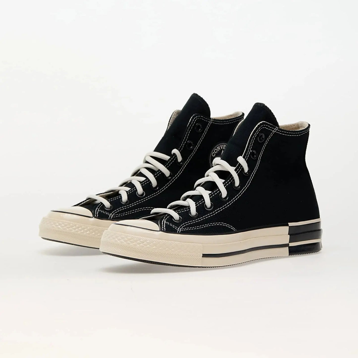 Baskets montantes noires et blanches Converse, lacets blancs et semelle épaisse crème.