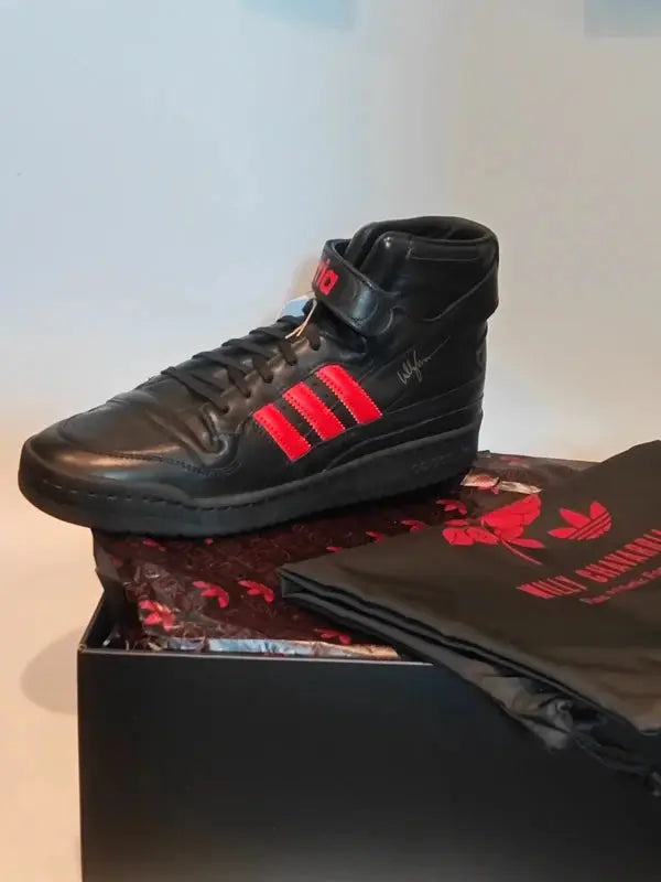 Baskets montantes noires et rouges Adidas x Willy Chavarria avec signature manuscrite sur boîte et sac noir imprimé.