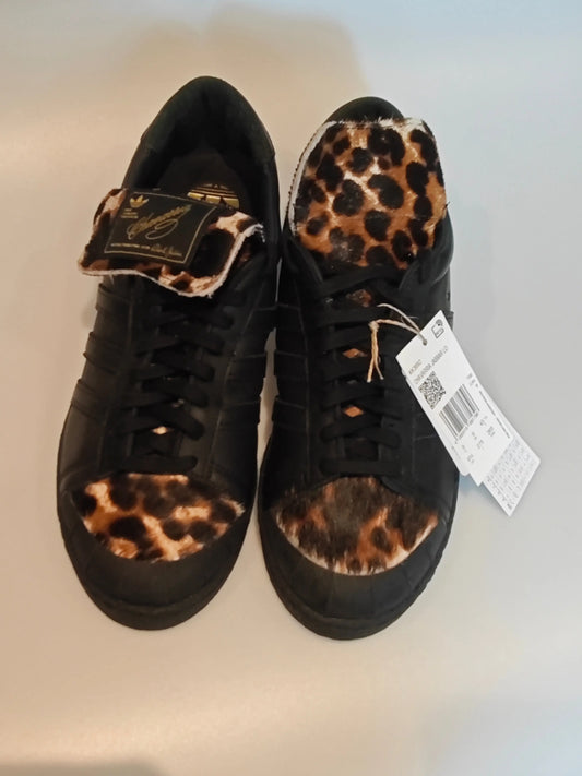 Basket en cuir noir par Adidas, avec motif léopard sur l'avant et la languette.
