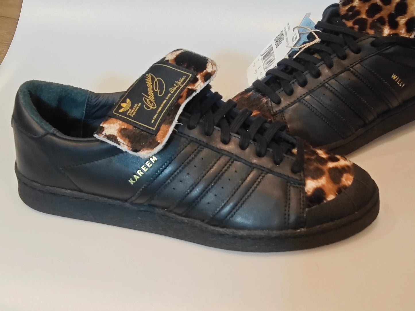 Baskets noires en cuir Adidas par Willy Chavarria, avec imprimé léopard sur le bout et languette décorée.
