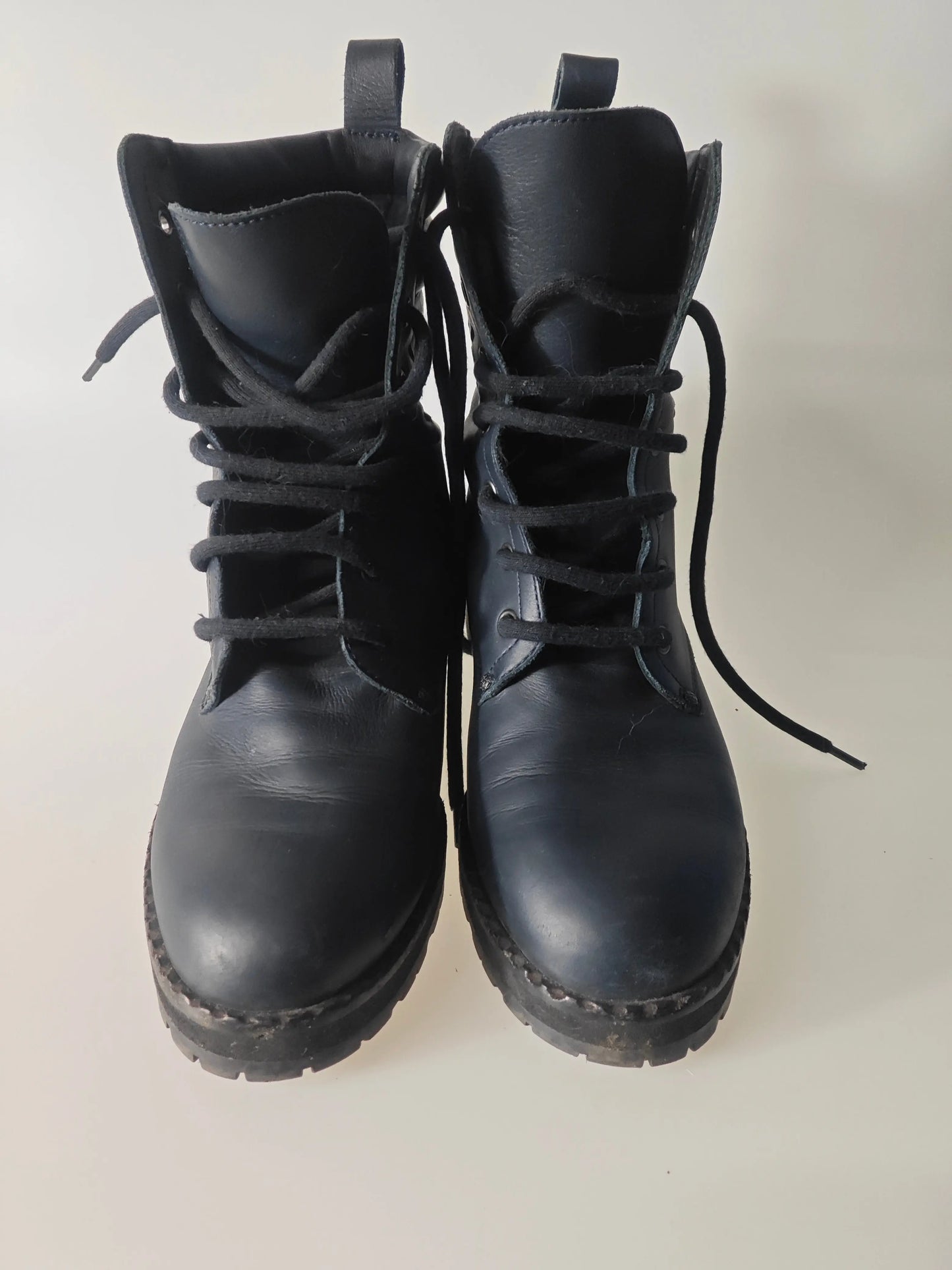 Bottines en cuir noir tressé de Bottega Veneta, modèle à lacets avec languette au dos.
