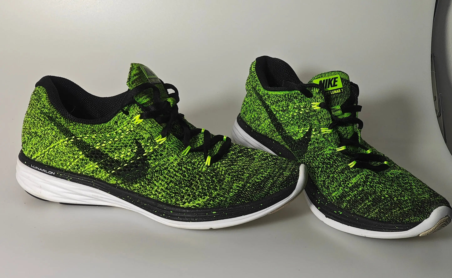 Baskets Flyknit vertes et noires de Nike, avec des lacets noirs et une semelle blanche.