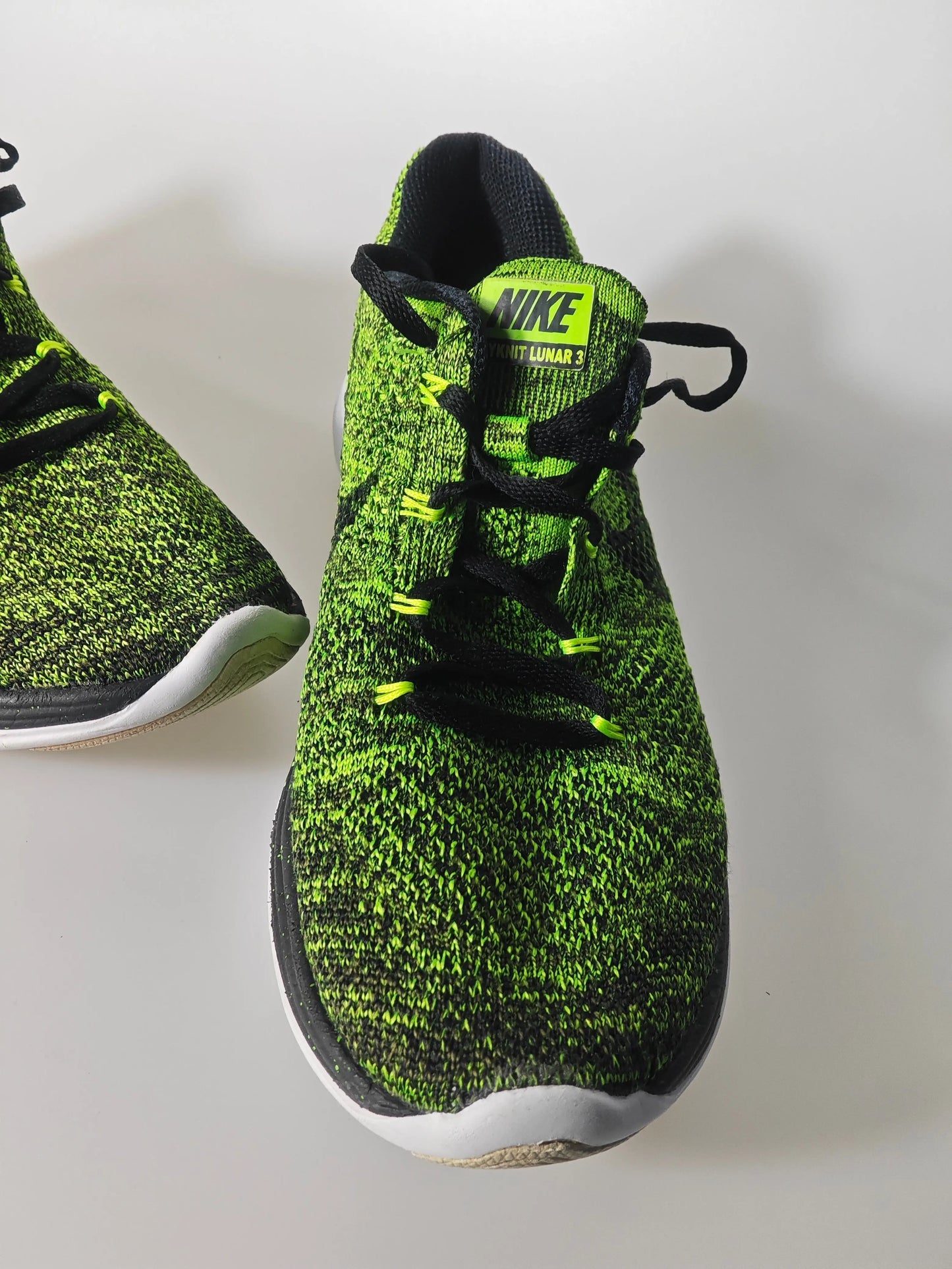 Baskets de course vert et noir Flyknit Lunar 3 de Nike, avec lacets noirs et semelle bicolore.

